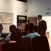 {
																																					A photograph of Joseph Barsby giving a community talk in front of an audience
																																			