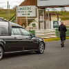 {
																																					A funeral hearse driving on Mallory Park racetrack
																																			